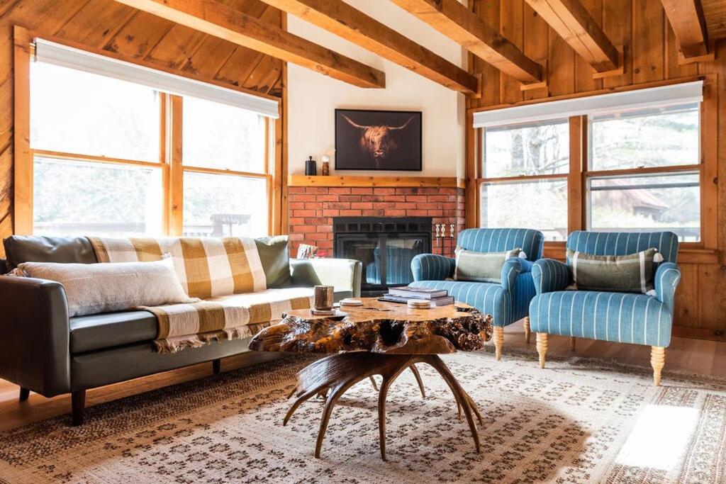 sala de estar con sofá, sillas y chimenea en New! Designer 3BR Cabin Walk to Pond Mtn Views, en Peru