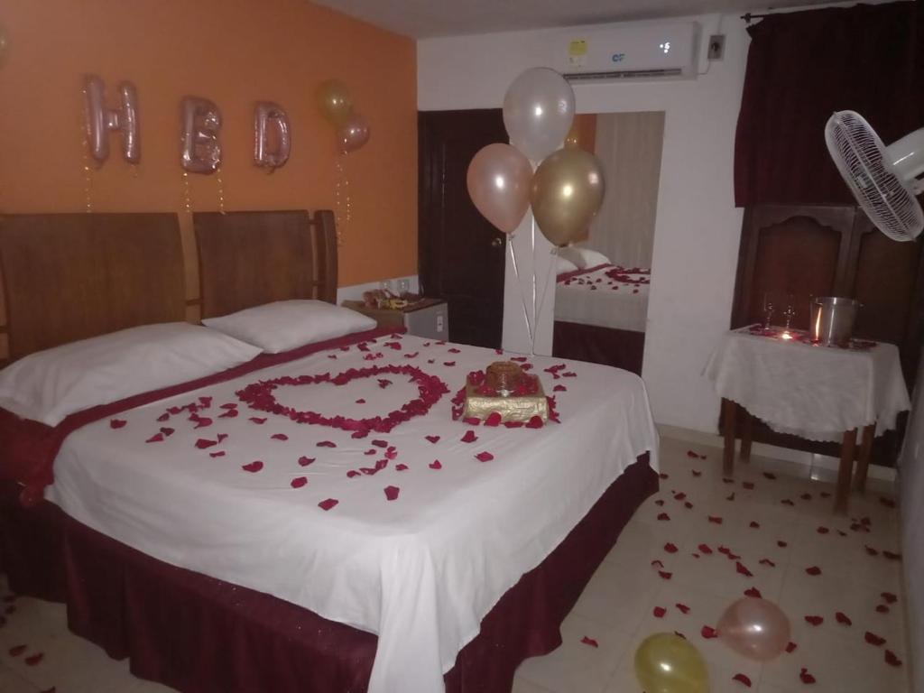 a bedroom with a bed with roses and balloons at Orempa Inn Hotel La Jagua in La Jagua de Ibirico
