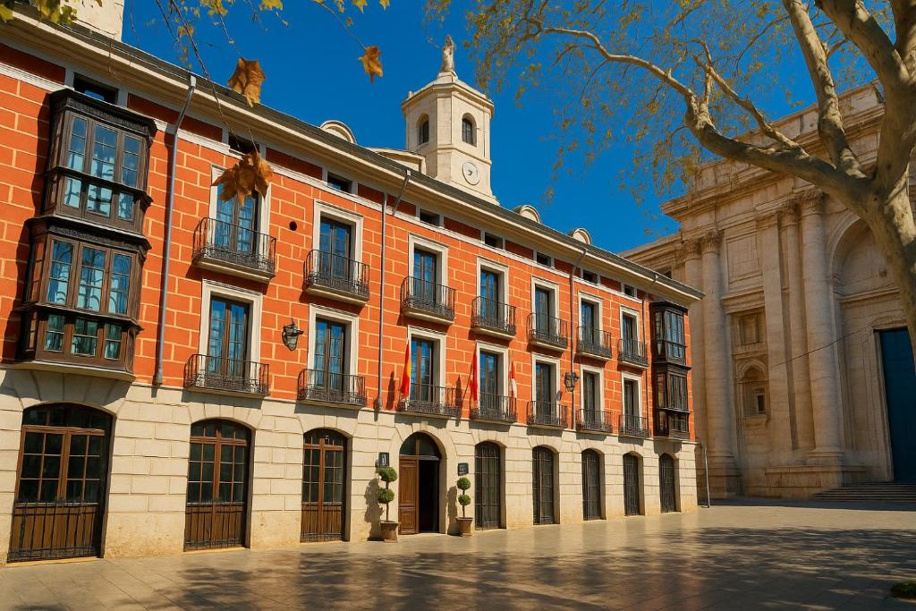 un grande edificio in mattoni con una torre dell'orologio in cima di Hotel El Coloquio a Valladolid
