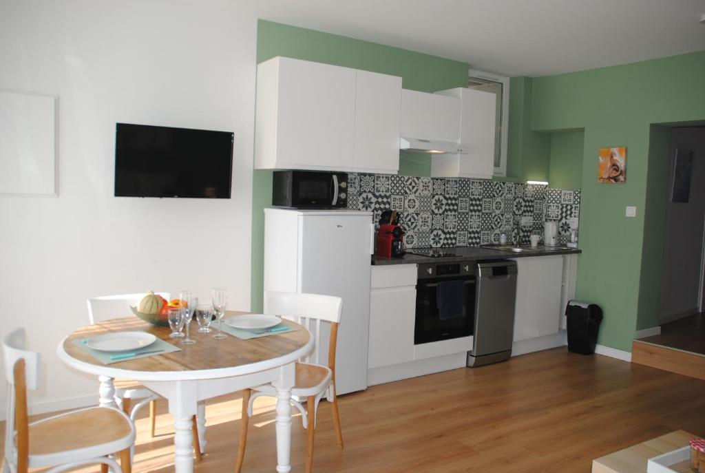 une cuisine avec une table avec des chaises et une salle à manger dans l'établissement Le lion d'Or DUO, à Malaucène