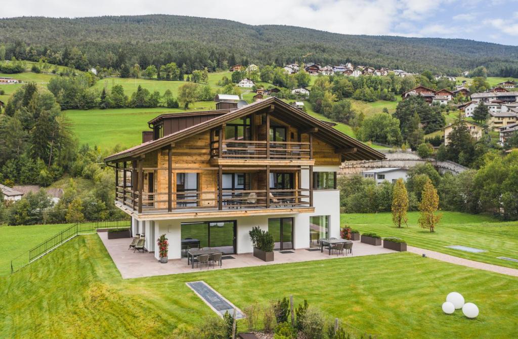 a house on a hill with green grass at Chalet Bel Plan in Ortisei