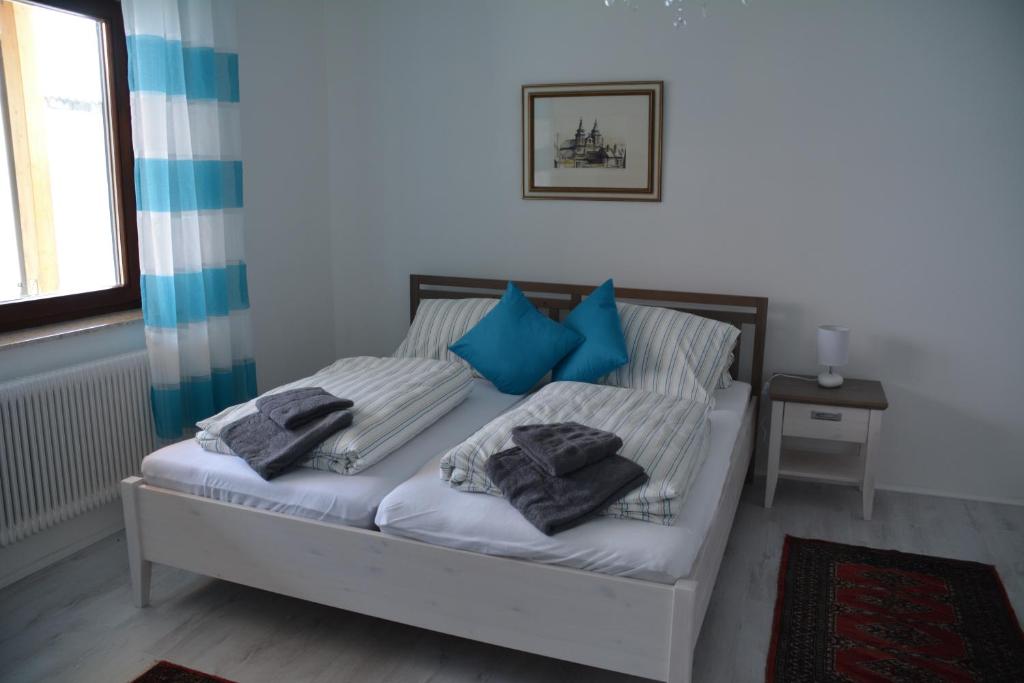 a bed with blue pillows on it in a room at Haus 4 you in Winden am See