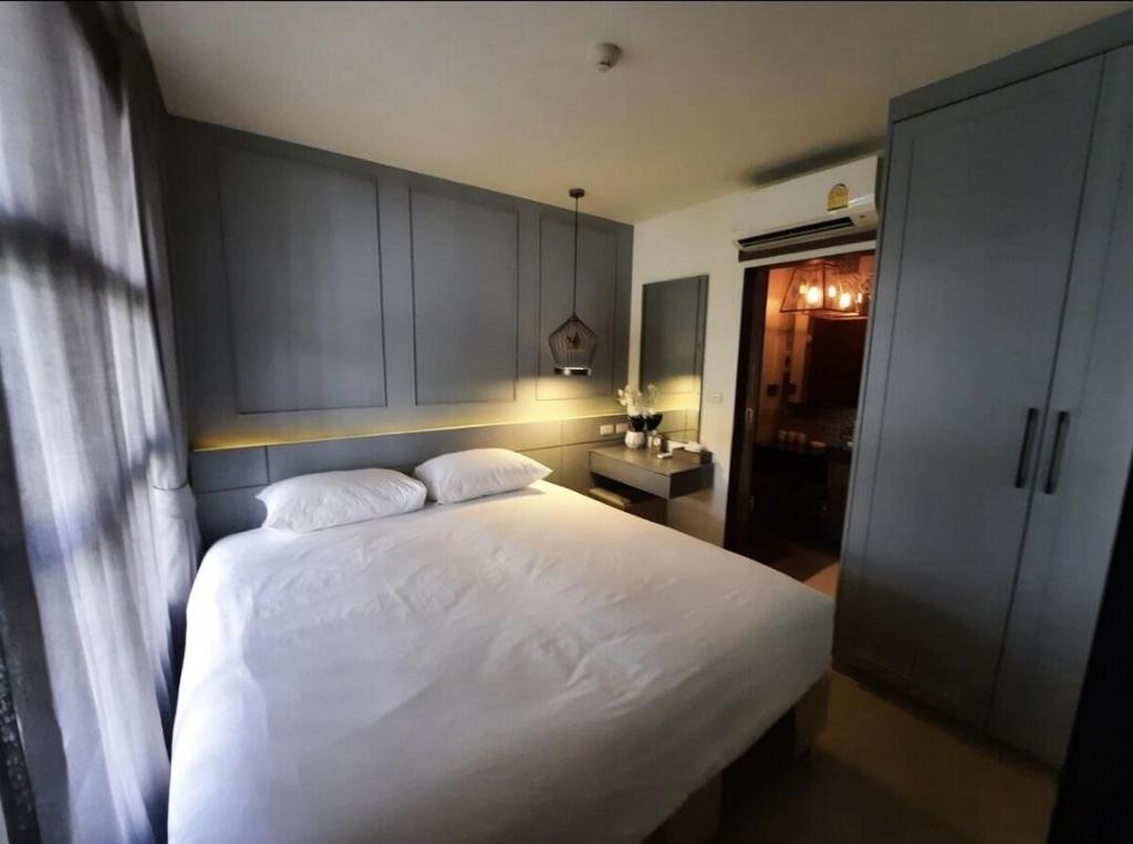 a bedroom with a large white bed and cabinets at The Palmirah Surin by SP in Surin Beach