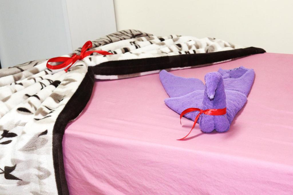 a purple teddy bear sitting on top of a bed at Hotel Rooms for rent Male only in Cairo