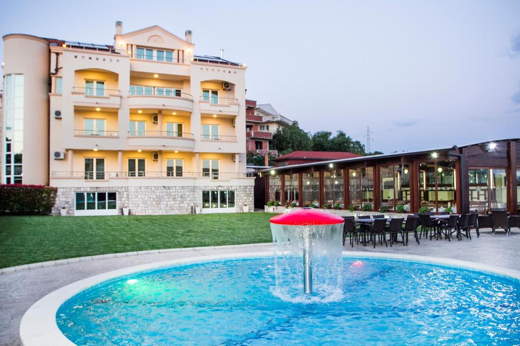 uma fonte numa piscina em frente a um edifício em Apart Hotel Llolla em Ulcinj