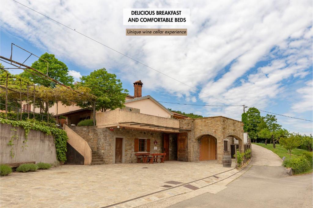una casa in pietra con un tavolo in un vialetto di Ražman Wine Rooms a Gračišče