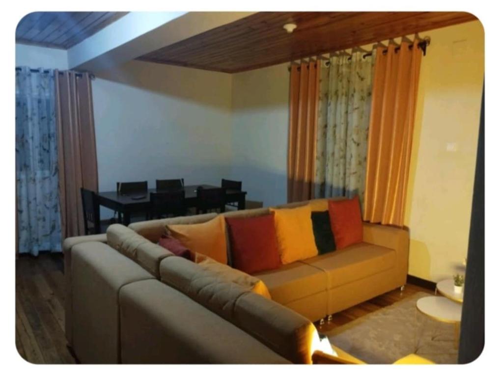 a living room with a couch with colorful pillows at villa EMMANUEL 1 in Antananarivo
