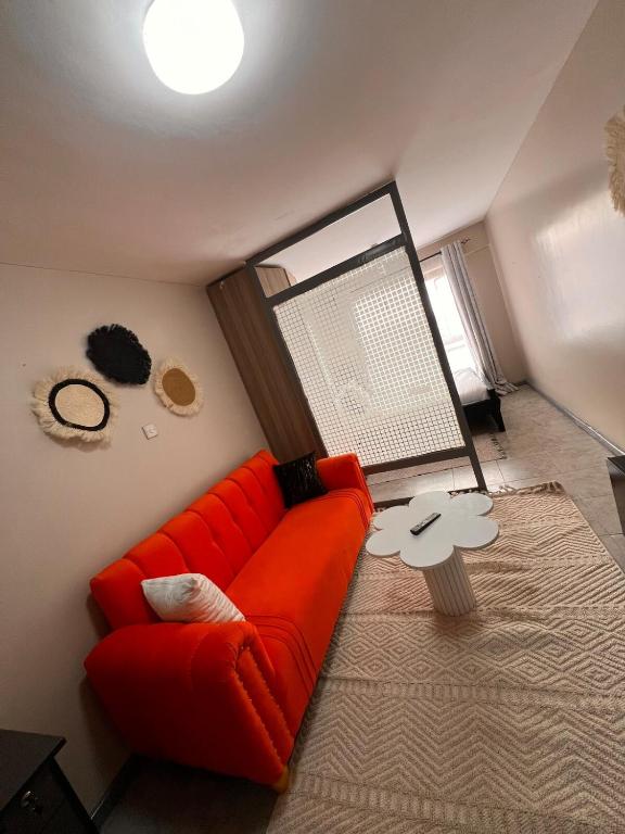 a living room with a red couch and a table at The cozy Cove in Nairobi