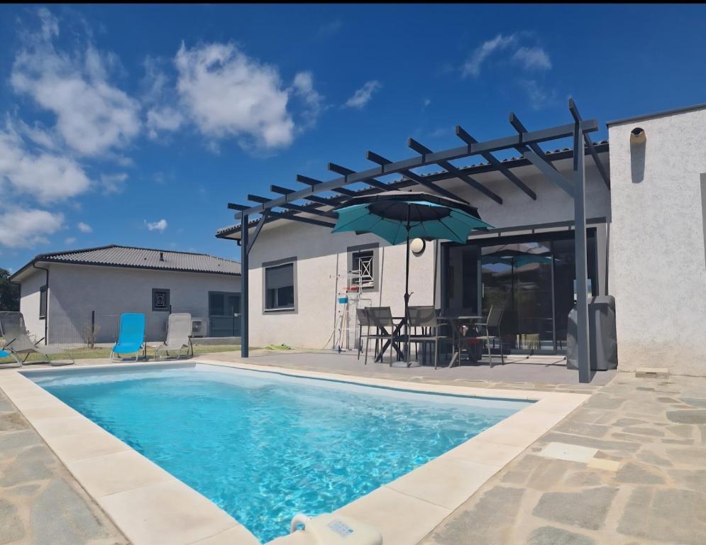 - une piscine avec une terrasse et un parasol dans l'établissement Villa Cosy avec piscine privative, à Ghisonaccia