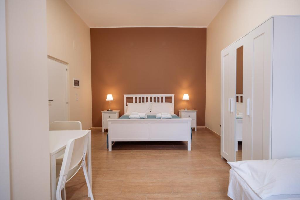 a bedroom with a white bed and two tables at Room Nabigi' - Centro Storico in Conversano