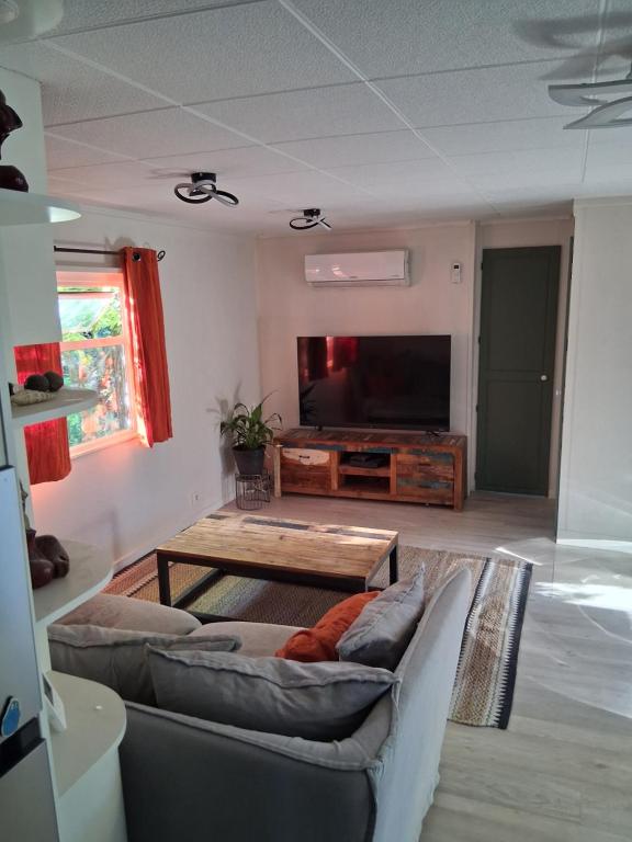 una sala de estar con un sofá y una mesa en Camping Les Acacias, en Saint-Paulet-de-Caisson