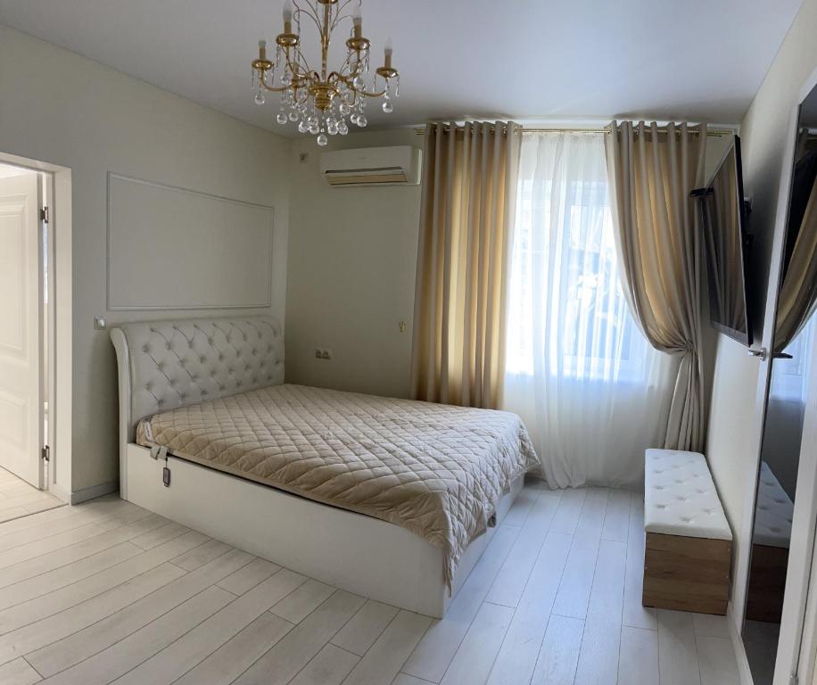 a bedroom with a large bed and a chandelier at Квартира в историческом центре Одессы in Odesa