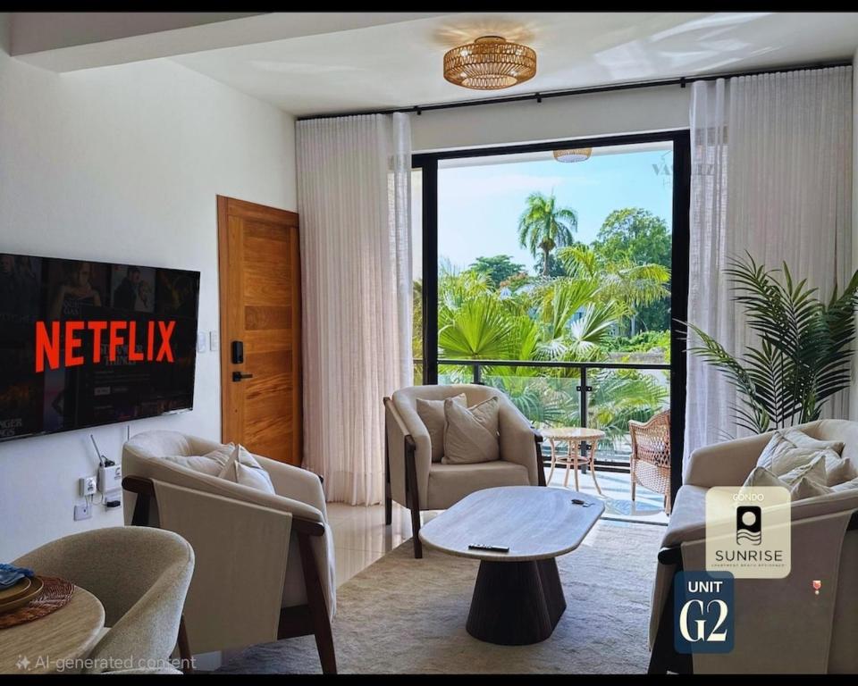 a living room with chairs and a table and a balcony at Brand New Condo-Sunrise in Puerto Plata