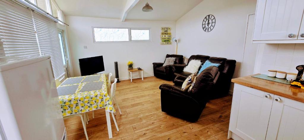 a living room with two couches and a table at Foxys Seaside Retreat in Withernsea