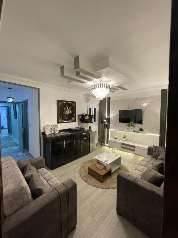 a living room with a couch and a table at Pyramids Elsewedy home in Ghaţāţī