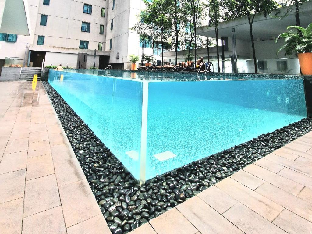 Summer Luxury Suites KlCC by ATIQ في كوالالمبور: مسبح كبير حوله صخور