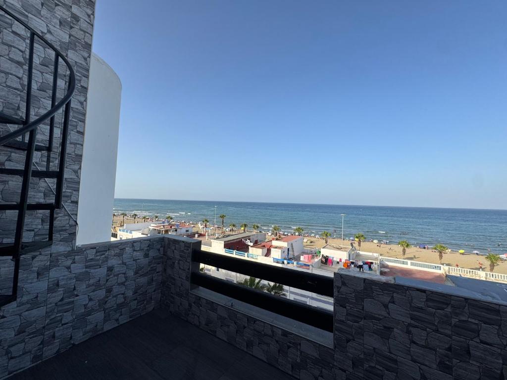 a balcony with a view of the beach at Duplex a martil 2 min plage in Martil