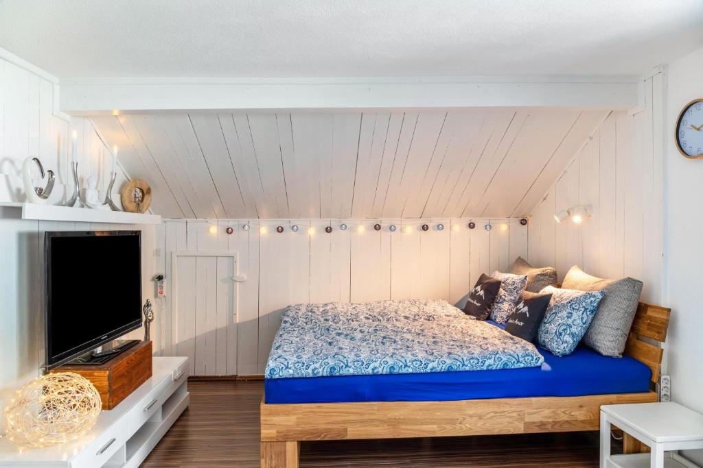 a bedroom with a bed and a flat screen tv at Ferienwohnung Montana Amor in Prutz