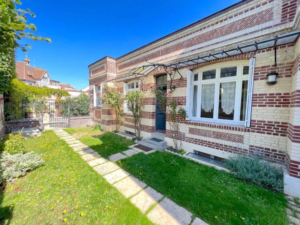 a brick house with a yard in front of it at Secret Brick Garden Deauville in Deauville
