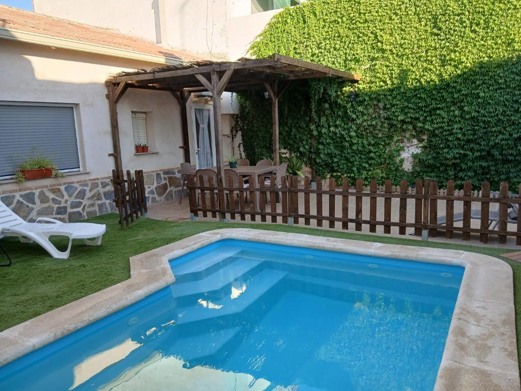 a swimming pool in a yard with a wooden fence at La Casa del Cerrillo in Sonseca