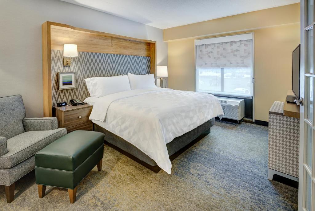 een hotelkamer met een bed en een stoel bij Holiday Inn East Windsor by IHG in Hightstown