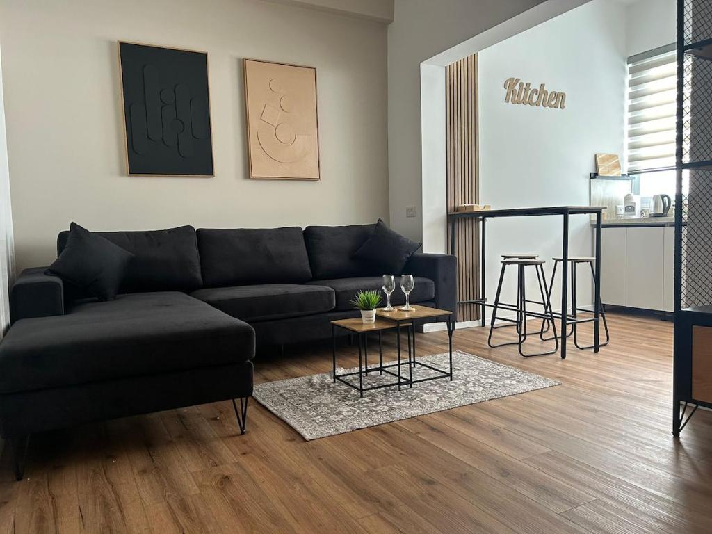 a living room with a black couch and a table at Eden apartment in Haifa