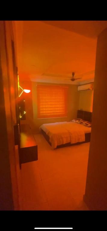 a bedroom with a bed and a window with a light at Ukayspot in Ifako