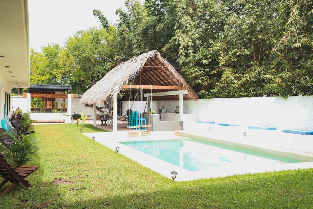 a house with a swimming pool with a thatch roof at Casa Kâi in Brisas de Zicatela
