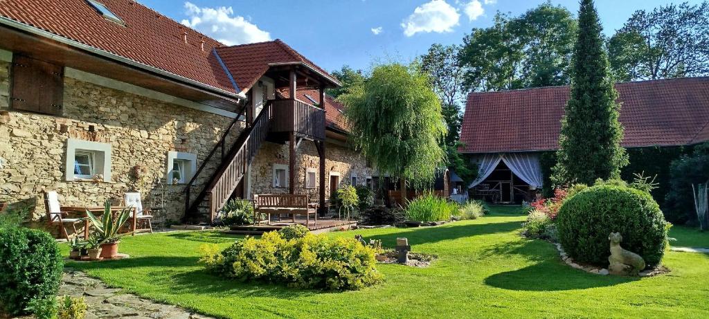 una vecchia casa in pietra con un cortile verde di Statek Kloubek a Chabičovice