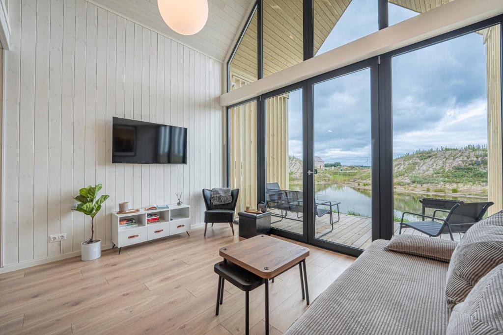 a living room with a couch and a tv at Pondside Cabin - Sauna - Terrace - Near Wake Park in Kiauleikiai