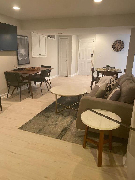 un salon avec un canapé, des tables et des chaises dans l'établissement Cozy 2BR suite w Sauna, à Leesburg