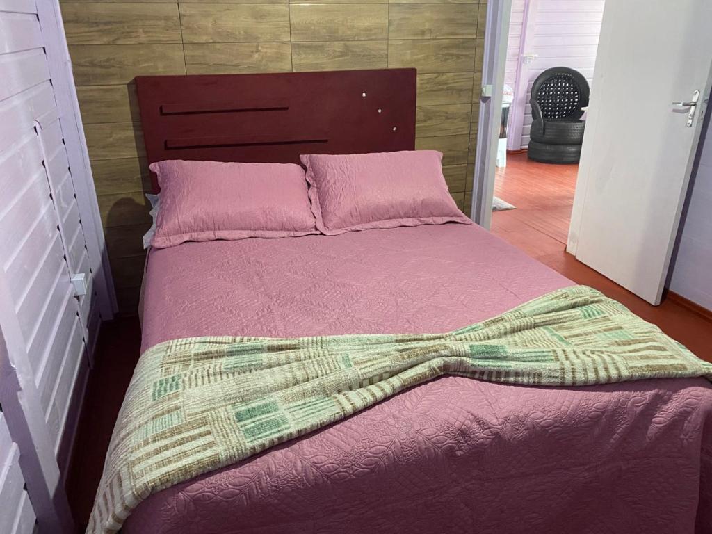 un lit avec une couverture rose et des oreillers roses dans l'établissement Monte Hermon hospedagem, à Bom Jardim da Serra