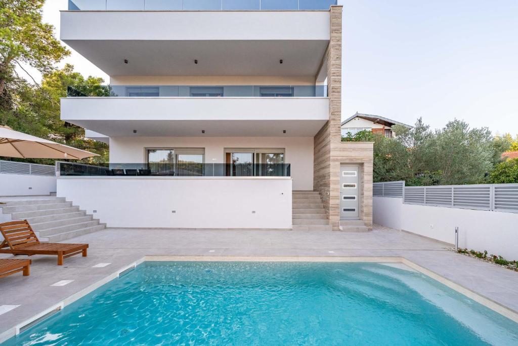 a house with a swimming pool in front of a house at Villa Bajlo in Ždrelac