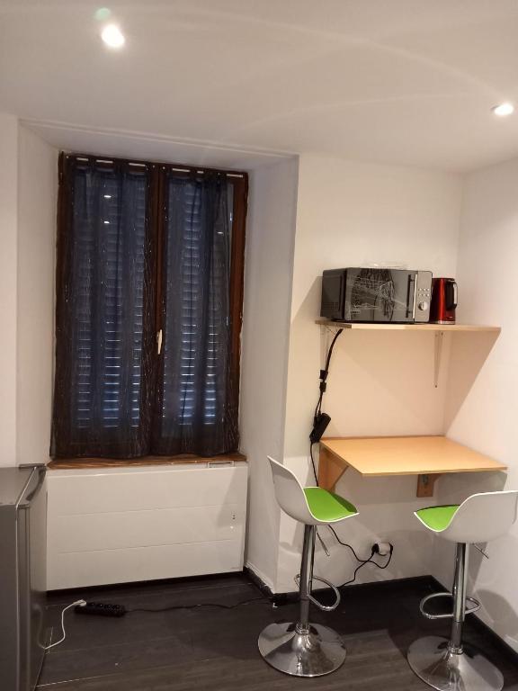 a room with a desk and two chairs and a window at Chambre à Pontarlier in Pontarlier