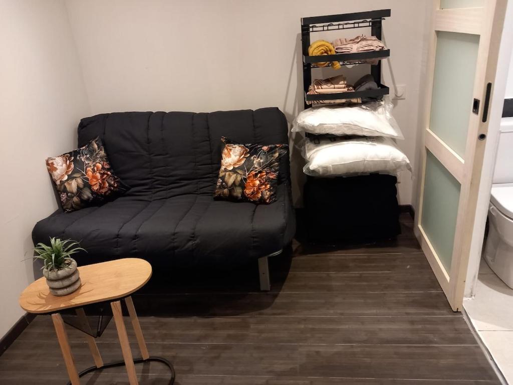 een zwarte bank in een kamer met een tafel bij Chambre à Pontarlier in Pontarlier