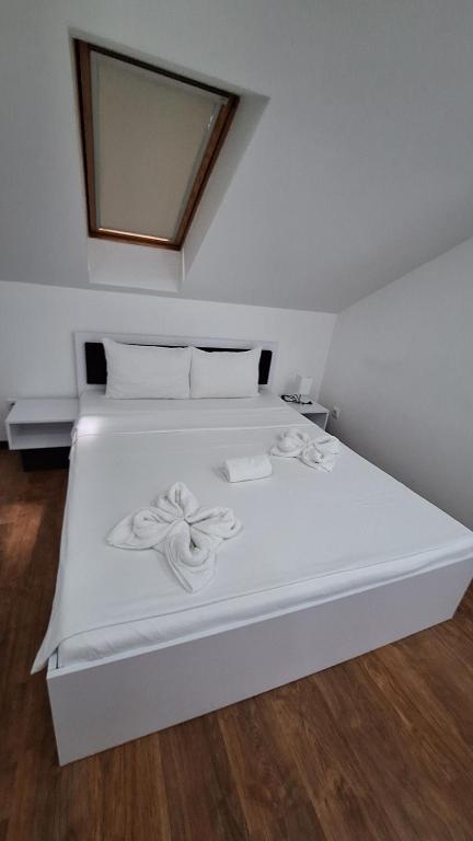 a white bed with two towels on top of it at S-Apartmani Cocetova in Jagodina