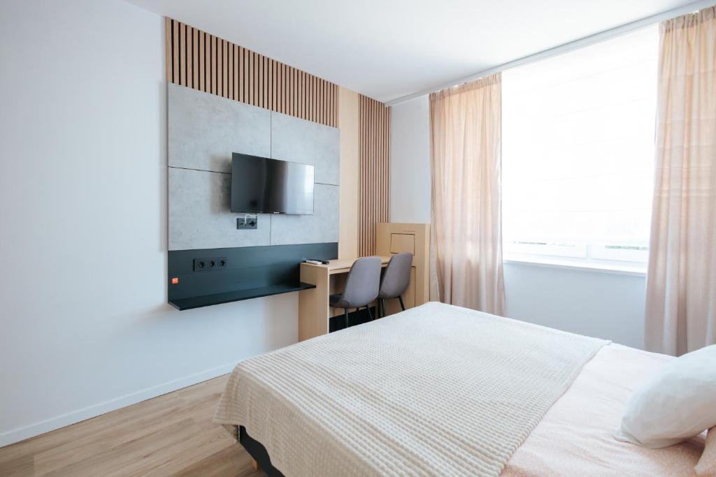 a bedroom with a bed and a desk and a tv at Noclegi Staś Krasnobród in Krasnobród