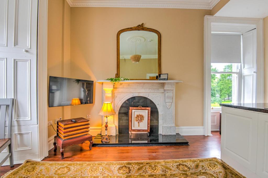 a living room with a fireplace and a mirror at Apartment 1, 2 Victoria Street, Armagh in Armagh