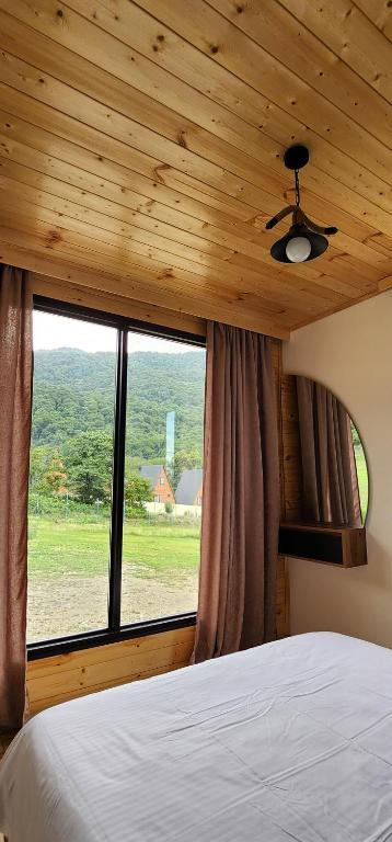 a bedroom with a bed and a large window at Netara in Khizabavra