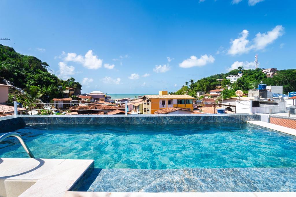 a swimming pool with a view of the ocean at Apartamento praça Morro de São Paulo in Cayru