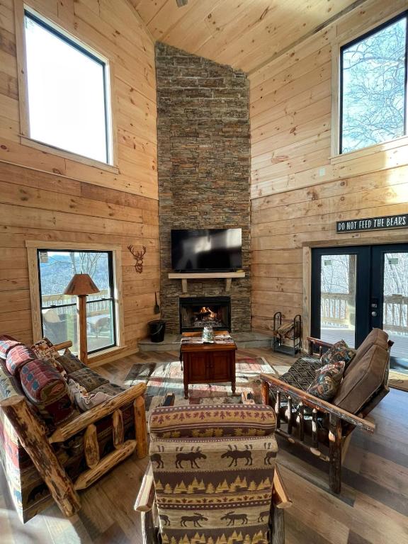 a living room with a fireplace and wooden walls at Mountain Heaven in Bryson City