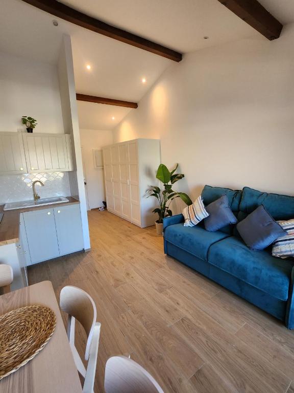 ein Wohnzimmer mit einer blauen Couch und einer Küche in der Unterkunft port grimaud in Grimaud