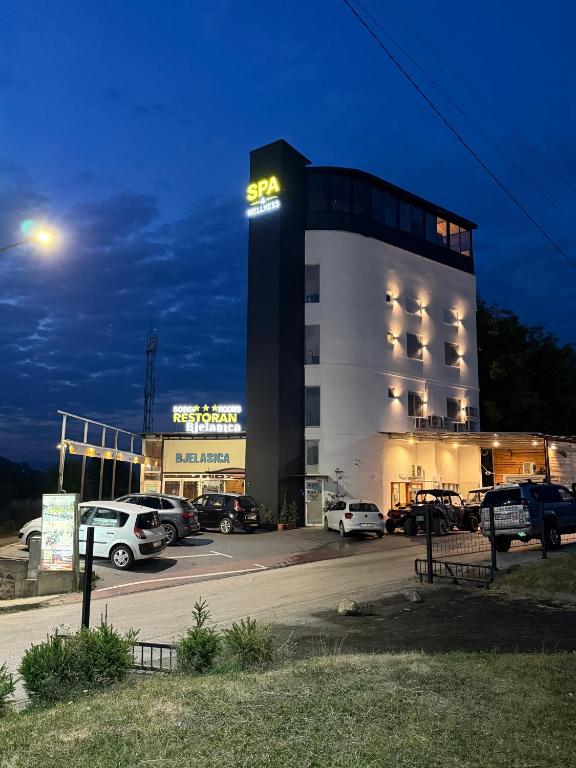 a building with cars parked in a parking lot at night at Rooms & Spa BJELASICA in Bijelo Polje