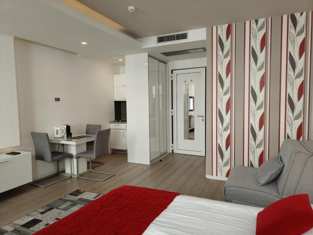 a bedroom with a bed and a desk and a kitchen at Central Point Privilege Apartments in Sarajevo