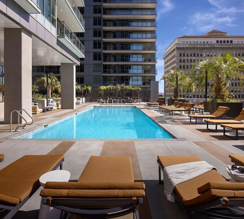 a swimming pool with lounge chairs and a building at The Daisy-Highrise 2BR Marina View,Pool,Jacuzzi,Gym&Parking in San Diego