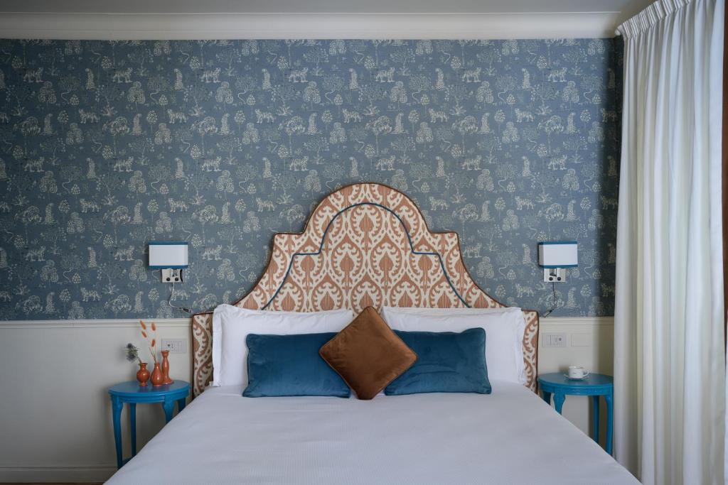 um quarto com uma cama grande e paredes azuis em Mabelle Centro em Florença