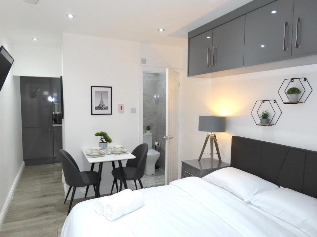 a bedroom with a bed and a table and chairs at 6 Mins to NEC & BHX Apartment with FREE Parking in Sheldon