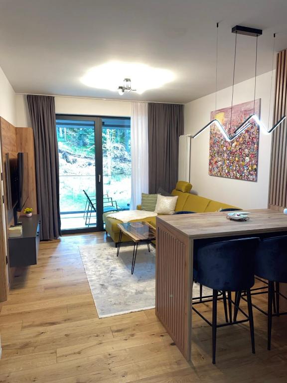 a living room with a couch and a table at Apartman Yellow Bjelasnica in Bjelašnica