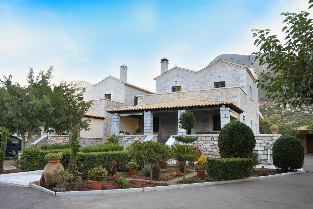 una gran casa de piedra con un jardín delante de ella en Thalori Retreat Areopoli, en Areopoli