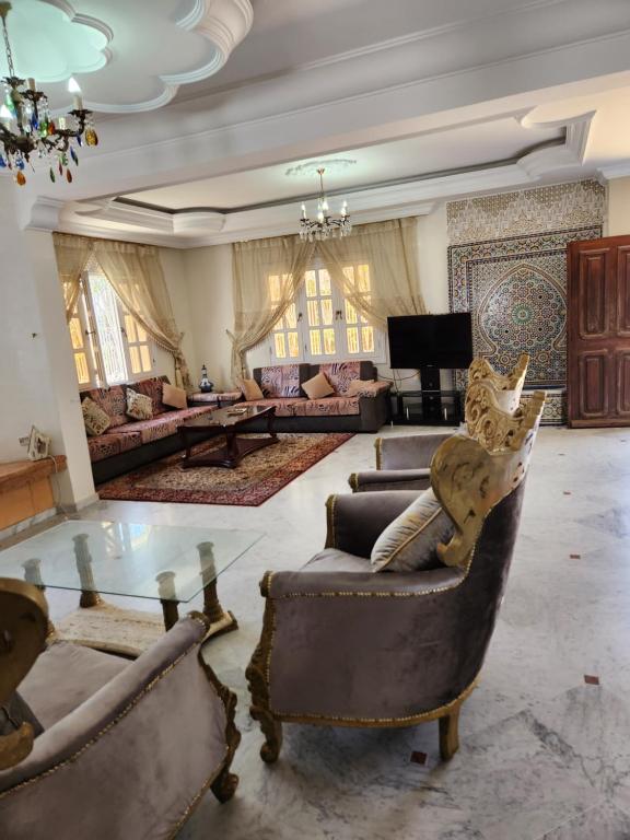 a large living room with couches and a glass table at Villa mouna in Mohammedia